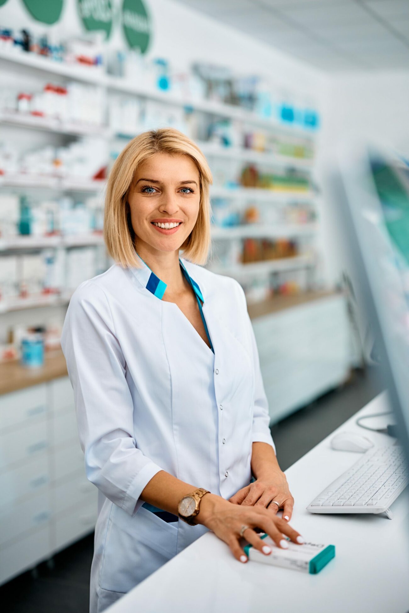 happy female pharmacist at work looking at camera